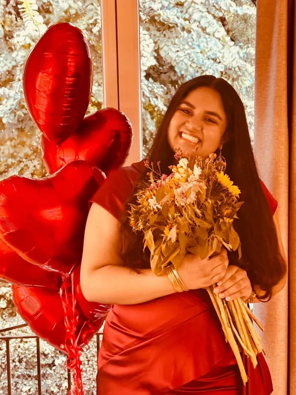 Shonairra Aradhya, founder of Sva Foundation, holding a bouquet of dried flowers.